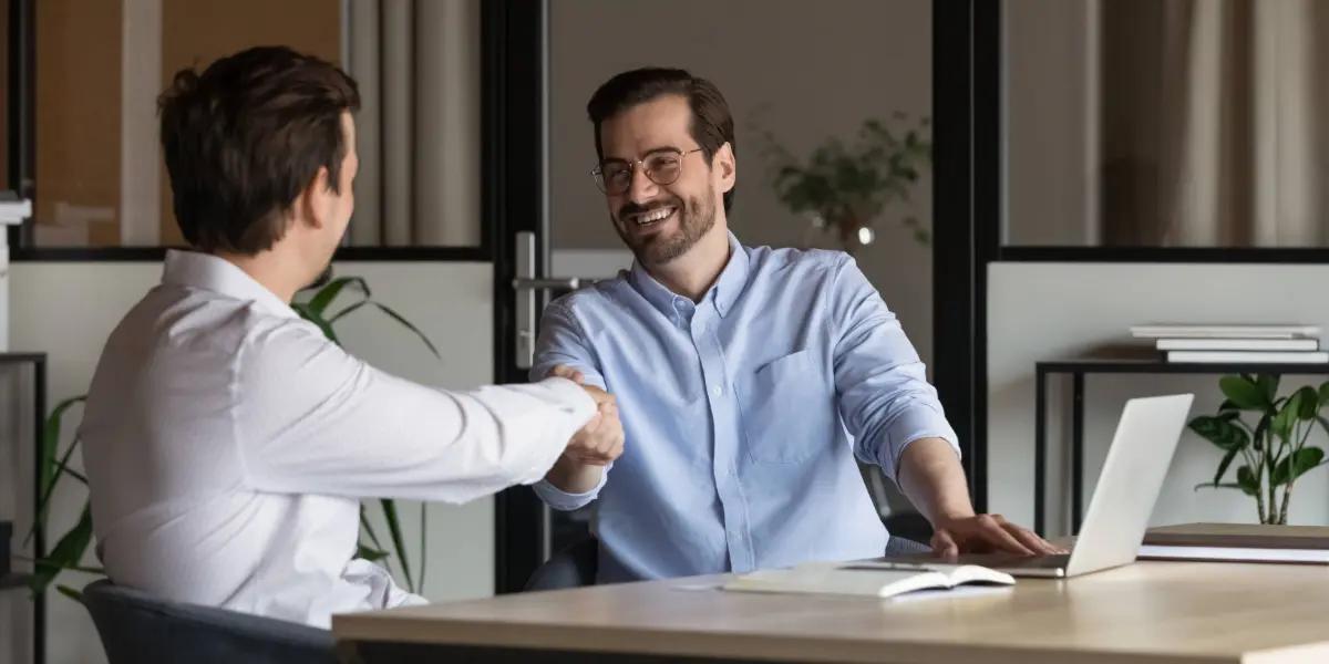 Corretor imobiliário fechando contrato com cliente.