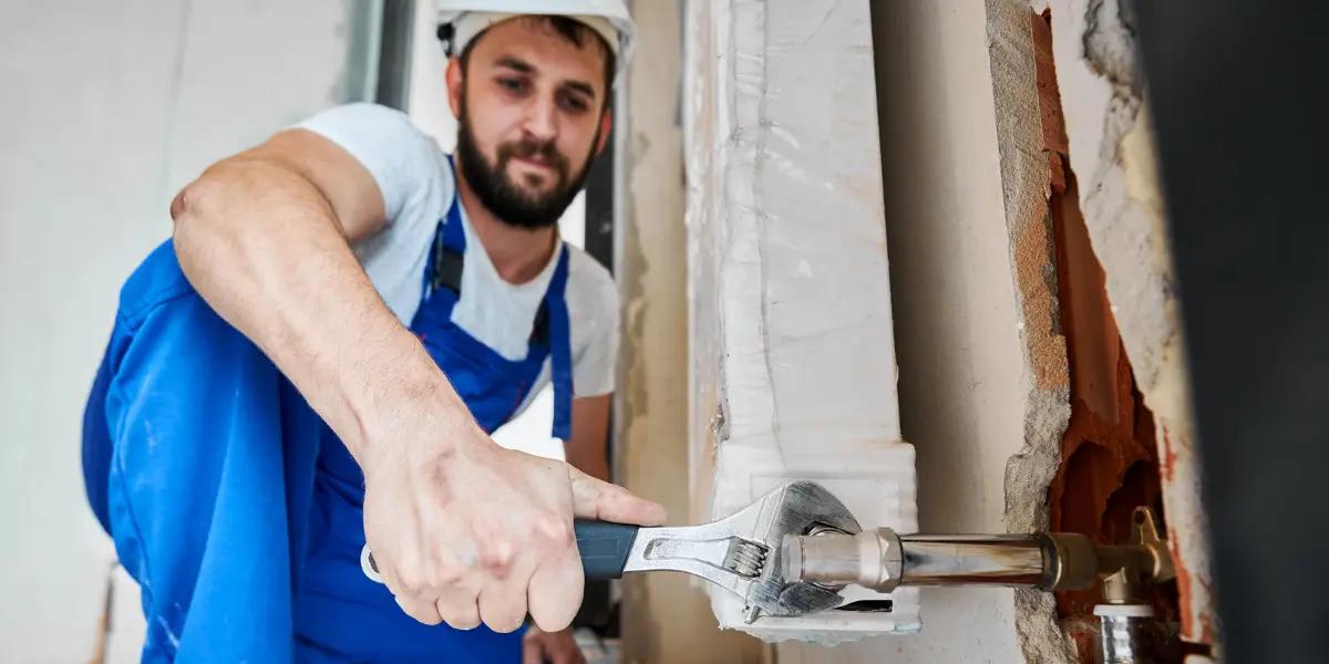 Homem consertando porta em casa alugada recentemente.