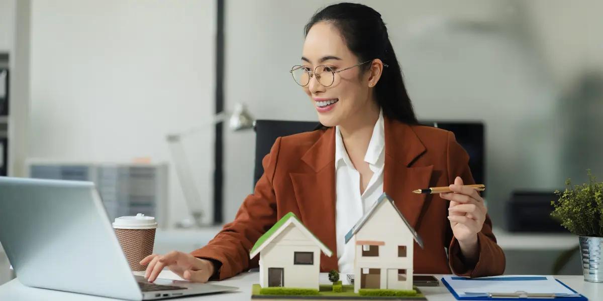 Corretora de imóveis escrevendo seus anúncios de imóveis em seu computador.