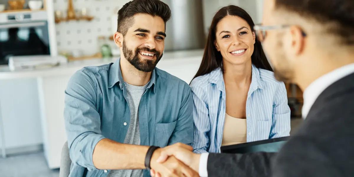 Corretor de imóveis atendendo um casal de clientes que estão em busca de um imóvel.