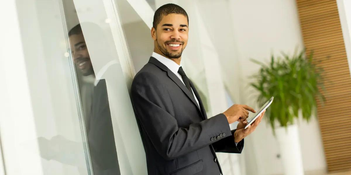 Corretor de imóveis pesquisando sobre como funciona o ciclo de vendas imobiliário em um tablet.