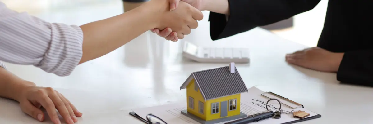 Imagem de corretores imobiliário apertando as mão após fechar contrato. 